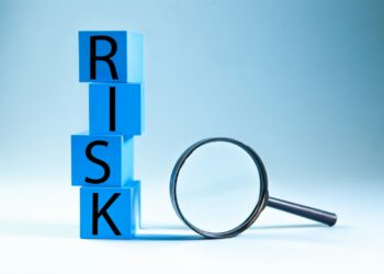 Mavi zemin üzerinde mavi bloklar ile RISK kelimesi yazılmış ve büyüteç duruyor.