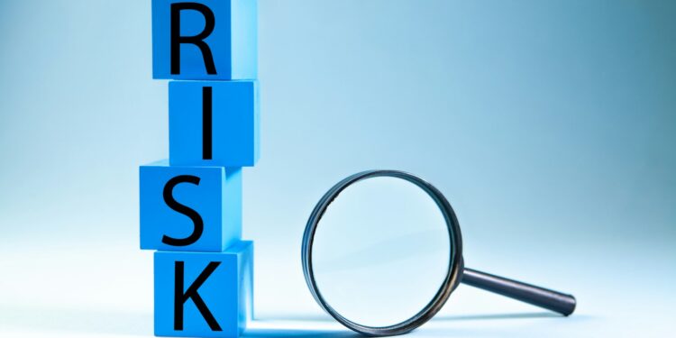 Mavi zemin üzerinde mavi bloklar ile RISK kelimesi yazılmış ve büyüteç duruyor.