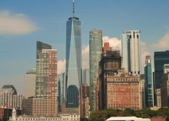 Masmavi gökyüzü altında yükselen New York silüeti ve modern gökdelenler.