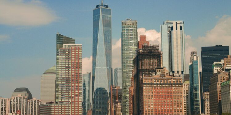 Masmavi gökyüzü altında yükselen New York silüeti ve modern gökdelenler.
