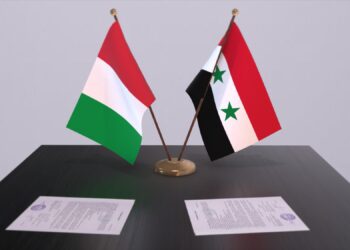 Masada duran iki ülke bayrağı ve önlerinde resmi evraklar yer alıyor.