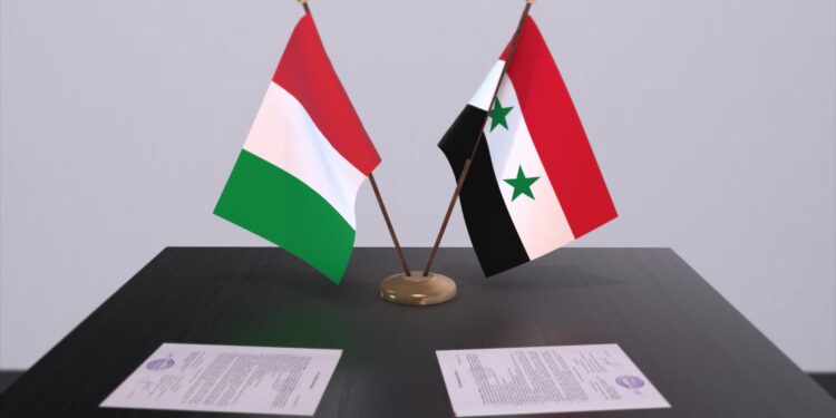 Masada duran iki ülke bayrağı ve önlerinde resmi evraklar yer alıyor.
