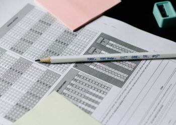 Sınav optik formu üzerinde duran bir kurşun kalem ve not kağıdı.