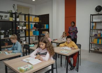 Sınıfta ders işleyen öğrenciler ve tahtanın önünde duran öğretmen