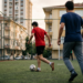 Sokak aralarındaki halı sahasında futbol oynayan gençlerin neşeli mücadelesi.
