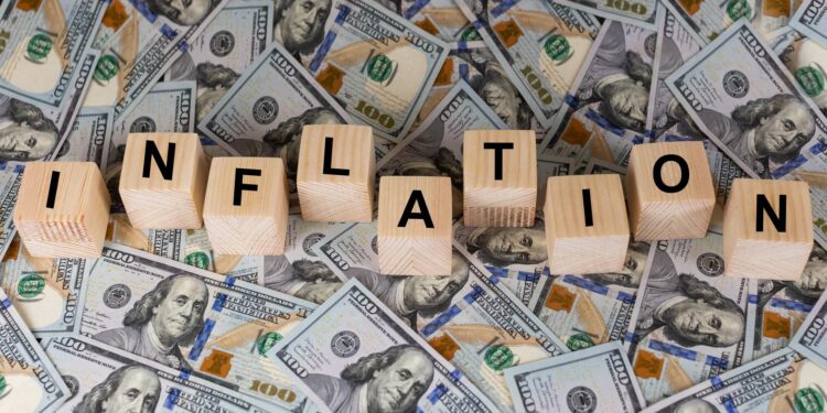 Yüz dolar banknotları üzerine yerleştirilmiş enflasyon kelimesi yazılı tahta bloklar.